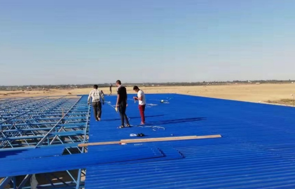 1 Men working on blue roof in desert