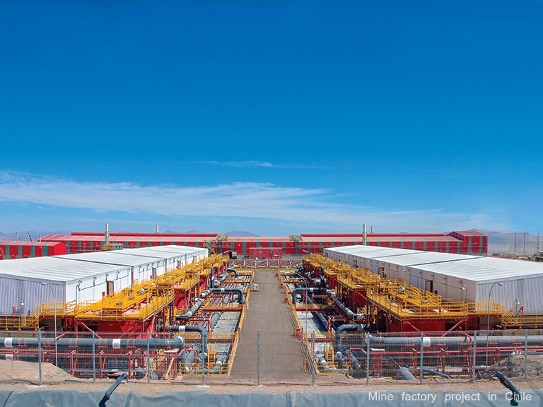1 a large industrial mine factory project in chile, featuring extensive piping, buildings, and a clear blue sky