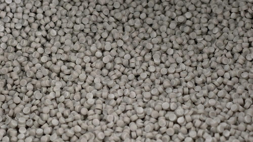 Close-up of light gray PVC compound granules used as raw material for UPVC roof sheet production and plastic roofing extrusion